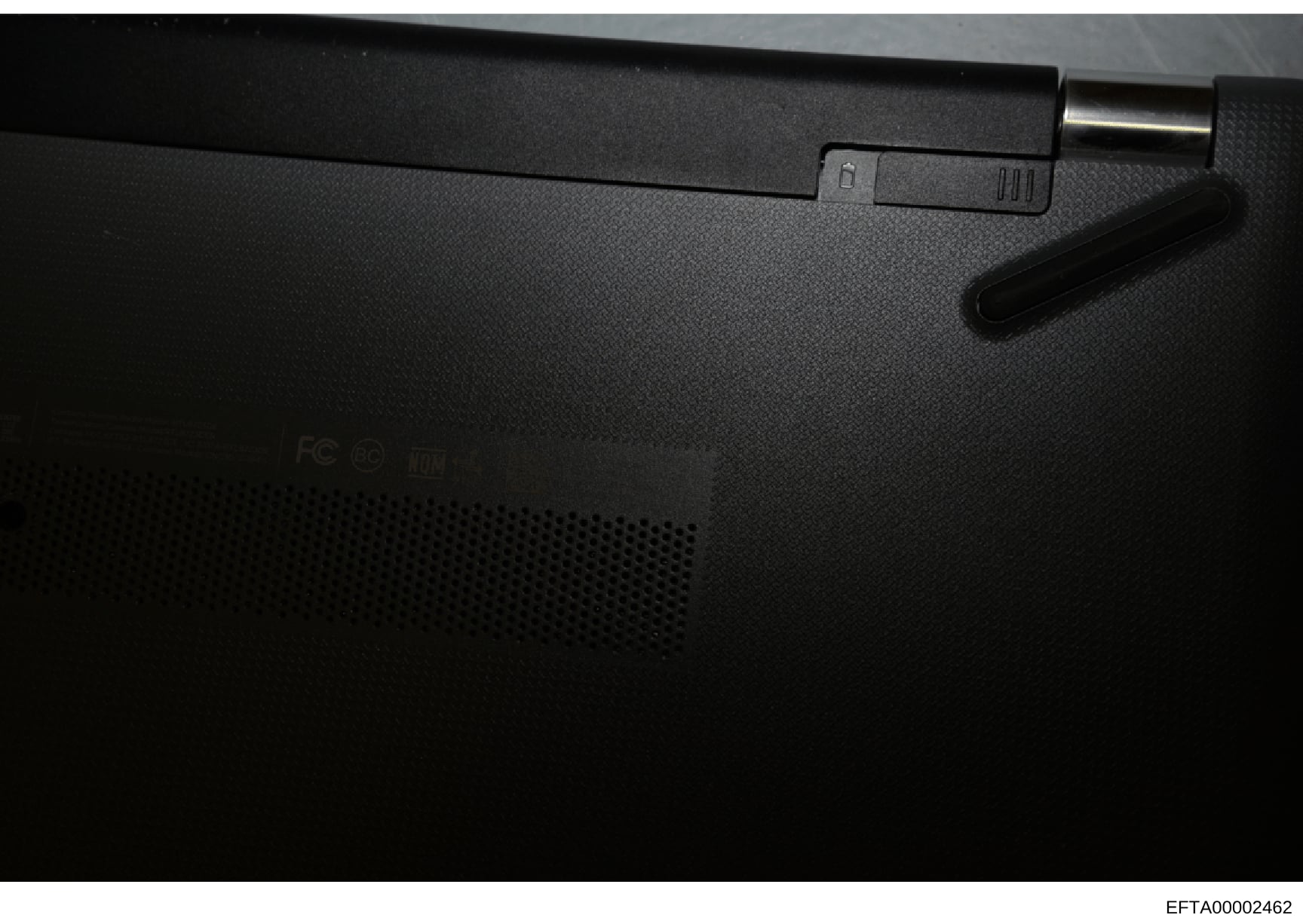 This photograph shows the back panel of an electronic device, likely a laptop or computer component, with minimal identifying markings visible. The image appears to be documentation of physical evidence or seized equipment from the investigation, tho
