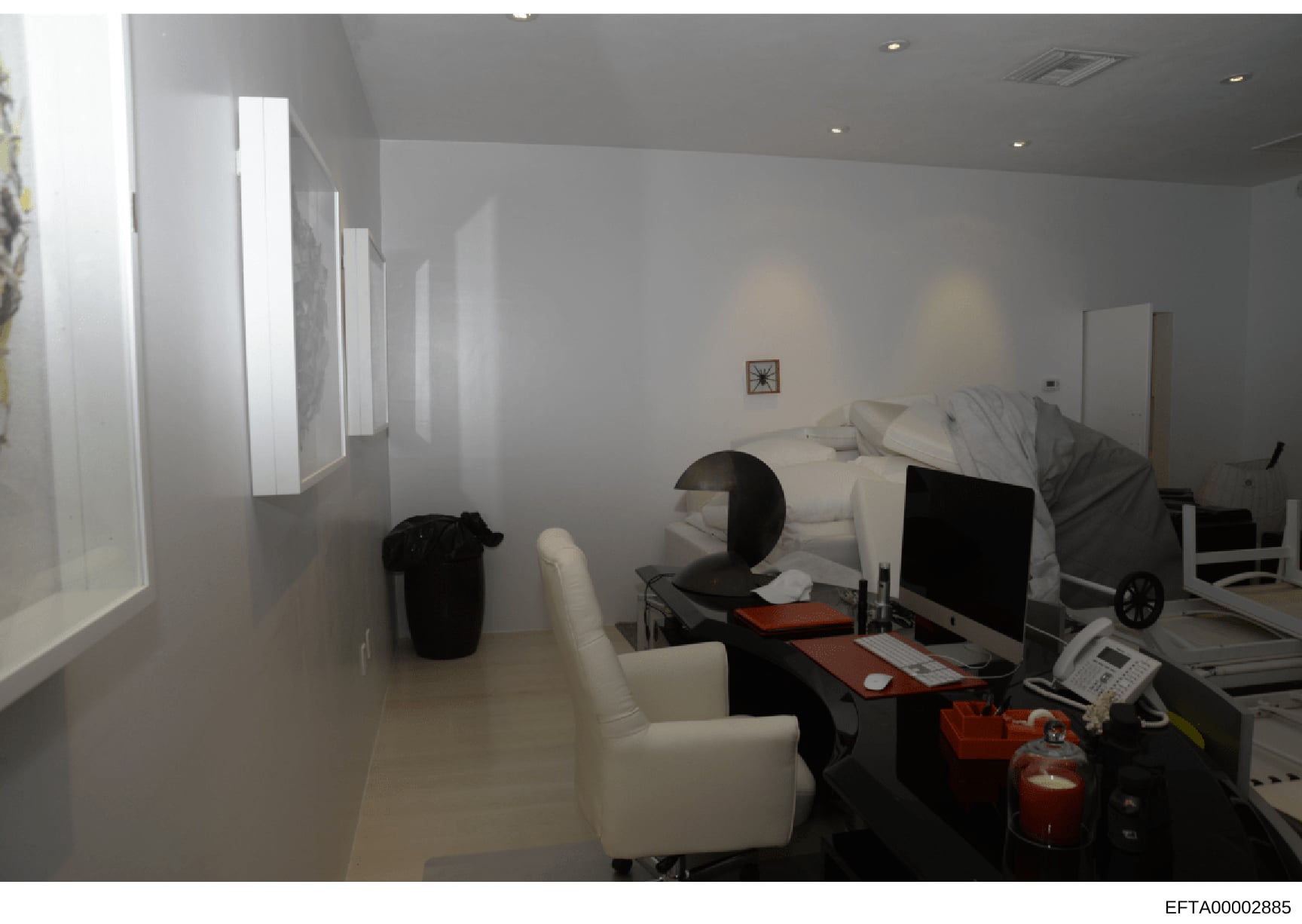 This is an evidence photograph showing the interior of a bedroom that appears to serve dual purposes as both a sleeping and working space. The room contains a bed, computer workstation, office furniture, and what appears to be medical or monitoring e