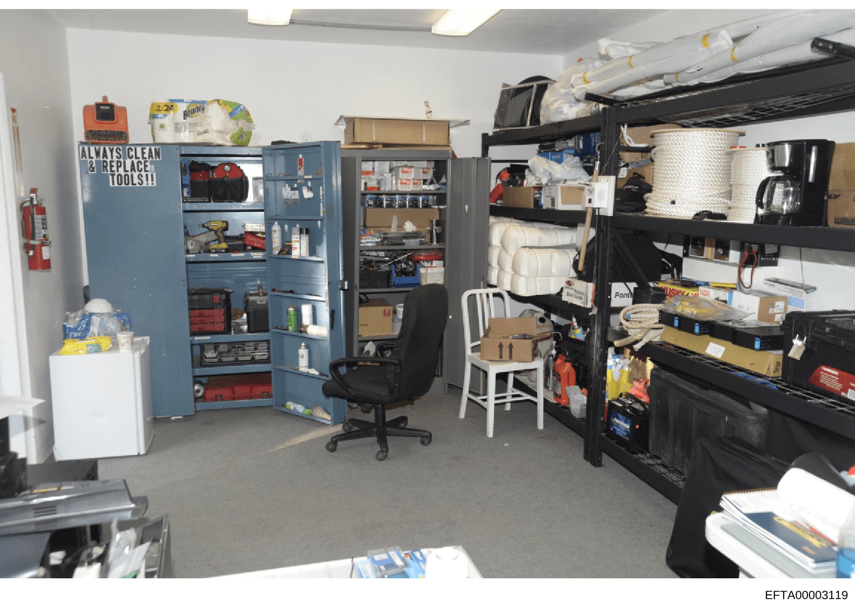 This is a photograph of an organized storage or maintenance room, likely from one of Jeffrey Epstein's properties. The space contains multiple storage cabinets, shelving units, tools, cleaning supplies, and household items. The room appears to be a u