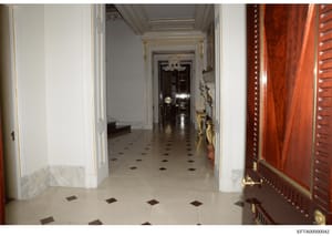 This is a photograph of an elegant, formal hallway in what appears to be Jeffrey Epstein's Manhattan townhouse at 9 East 71st Street in New York. The image shows classical architectural details including white walls with gold trim, a coffered ceiling
