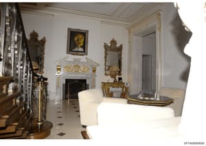 This is a photograph of an opulently decorated formal living room featuring neoclassical and rococo design elements, including ornate gold-leaf mirrors, a white marble fireplace with gilded details, fine furniture, and classical artwork. The room app