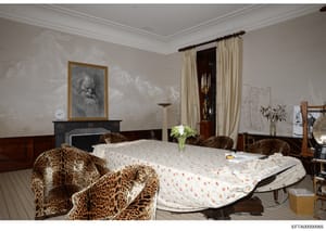 This is an evidence photograph showing the interior of a high-end residential bedroom, featuring luxury furnishings including leopard-print upholstered chairs, a fireplace with artwork, and formal décor. The photograph appears to be from an investiga