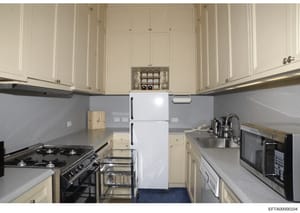 This is a photograph of a residential kitchen, showing appliances, cabinetry, and countertops. The image appears to be documentation of a property interior, likely taken as part of property inventory or investigation evidence. The kitchen features cr