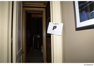This photograph shows an interior doorway of a residential property with an evidence marker labeled 'P' attached to the door frame. The image appears to be part of a property inspection or law enforcement documentation, likely taken during a search o