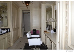 This photograph shows an elegant, high-end residential dressing room or bathroom area featuring cream-colored cabinetry, mirrors, decorative lighting, and contemporary furnishings. The space exhibits luxury finishes consistent with Epstein's known re