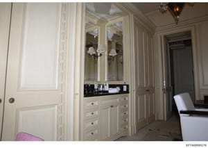 This photograph shows a high-end bathroom interior featuring a custom vanity with mirrored cabinet, built-in storage drawers, and cream-colored cabinetry. The image appears to be documentation of interior spaces within a property under investigation,