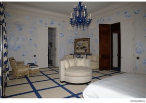 This is a photograph of an elegantly decorated bedroom featuring blue and white Chinoiserie-style wallpaper, luxury furnishings, and high-end design elements. The room appears to be part of a substantial residence and shows sophisticated interior des