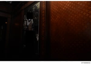 This is an evidence photograph showing the interior of a luxuriously decorated room with rich wood paneling, ornamental borders, and a framed portrait on the wall. The image captures the opulent furnishings and decor consistent with Epstein's known p
