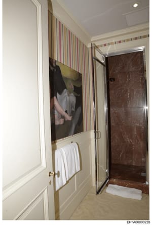 This photograph shows a bathroom interior space, likely from one of Jeffrey Epstein's properties. The image depicts a modern bathroom with striped wallpaper, a marble shower enclosure, white towel rack, and artwork on the wall. The photo appears to b