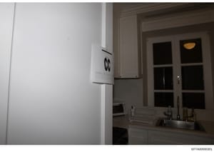 This photograph shows an interior kitchen space with modern white appliances, cabinetry, and a window with glass doors. The image appears to be documentation of a residential property, likely taken as part of an evidence collection or property invent