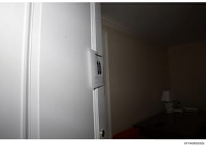 This is a photograph of an interior room showing a built-in appliance (appears to be a wall-mounted unit with dual vents) visible through a doorway. The image captures minimal detail of the space and may be part of a property documentation or evidenc
