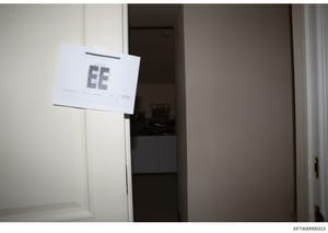This is an evidence photograph showing the interior of a room with a white evidence label marked 'EE' affixed to a wall or surface. The label appears to be part of a crime scene or property documentation, indicating this photo was taken as part of an