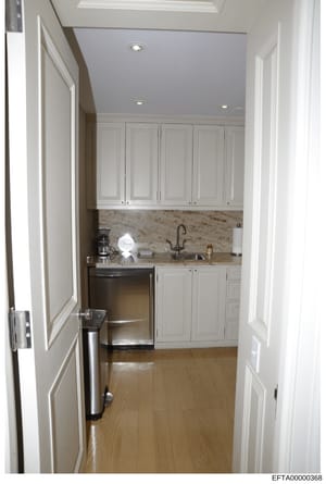 This is a photograph of a residential kitchen or kitchenette space, showing modern cabinetry, stainless steel appliances, granite countertops, and contemporary fixtures. The image appears to be evidence documentation from a property inspection or inv