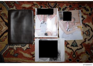 This is an evidence photograph showing a black leather wallet or document case alongside several printed photographs laid out on an ornamental red and gold patterned rug. The visible photographs appear to be personal snapshots, with faces redacted fo