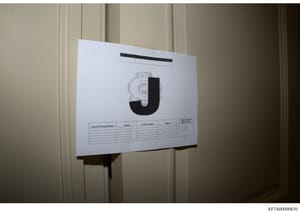 This is a photograph of an evidence or file cover sheet used in the investigation, displaying a large letter 'J' (likely indicating a file category or section marker). The document contains a table with columns for Search Personnel Name, Agency, Cont