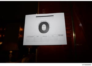 This is a photograph of an evidence documentation card used in the Epstein investigation. The card displays a large circular dark redaction covering what appears to be a photograph of an item or person, with a standard evidence form below containing 