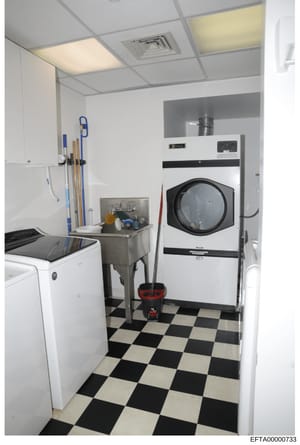 This is a photograph of a residential laundry room, showing washing and drying equipment along with cleaning supplies. The image appears to be part of property documentation or inventory associated with the investigation.