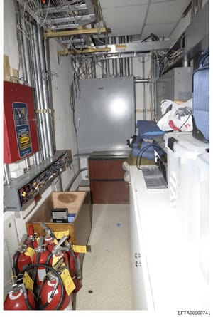 This is a photograph of an interior utility or equipment room, showing electrical infrastructure, fire safety equipment, HVAC systems, and storage areas. The image appears to be taken during a property inspection or evidence documentation process and