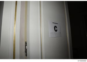 This is an evidence photograph showing an interior door or wall panel with a large evidence marker labeled 'C' affixed to it. The photo appears to be from a law enforcement evidence collection process, documenting the location and condition of an ite