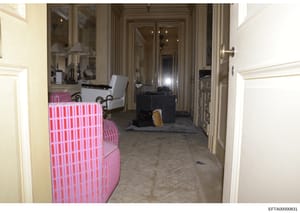 This is an evidence photograph of an interior hallway or dressing area, likely from one of Epstein's properties. The image shows distinctive pink and white striped upholstered furniture, mirrored walls, decorative lamps, and cream-colored architectur