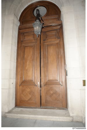 This is an evidence photograph of an ornate wooden double-door entrance, likely from one of Epstein's properties. The photo shows classical architectural details including an arched transom window above the doors and a period lantern fixture. This im