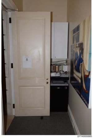 This is an evidence photograph showing the interior of a room, likely from one of Epstein's properties. The image depicts a cream-colored two-panel door marked with evidence label 'A', along with office equipment including a printer/copier, shelving 