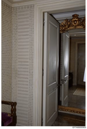 This photograph documents the interior of a high-end residential property, showing a hallway with designer wallpaper, custom paneled doors, and ornate gold-framed mirror. The image appears to be from one of Epstein's properties and serves as evidence