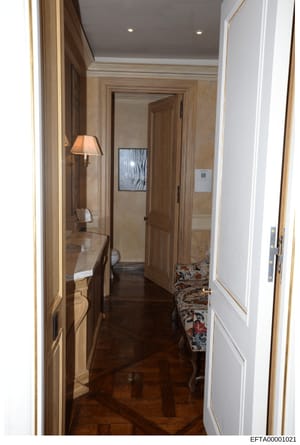 This photograph shows an upscale residential hallway featuring elegant wood paneling, marble walls, recessed lighting, and high-end finishes. The image appears to be documentation of interior spaces from one of Jeffrey Epstein's properties, likely ta