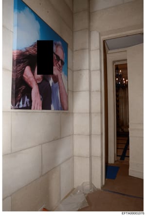 This is an evidence photograph of an interior room space showing a hallway or corridor with cream-colored tile walls. The image captures artwork or a poster mounted on the wall featuring what appears to be a portrait with blue and pink tones, with a 