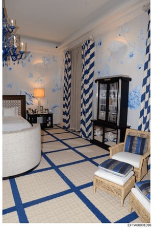 This is a photograph of an elegantly decorated bedroom featuring a sophisticated color scheme of blue, white, and cream. The room displays high-end interior design with custom wallpaper, quality furnishings, and professional styling. The image appear