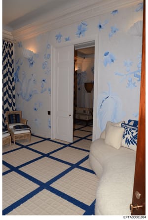This photograph shows an elegantly decorated interior room featuring blue and white botanical wallpaper, white crown molding, and geometric patterned flooring with navy blue accents. The room contains upholstered furniture and is part of the evidence
