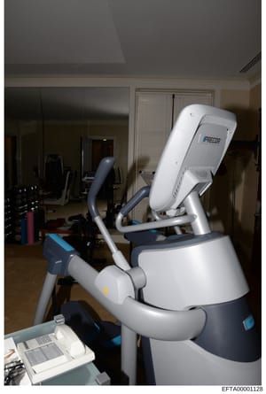 This photograph shows a Precor brand exercise machine (appears to be an elliptical or similar cardio equipment) located in a residential home gym or fitness space. The image documents the interior of what appears to be a luxury residential property's