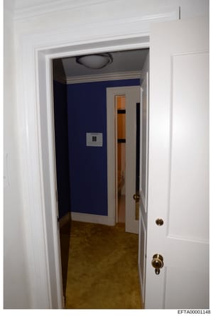 This is a photograph of an interior hallway in what appears to be a residential or commercial property. The hallway features white trim, dark blue wall paneling, and a room marked with 'BB' visible through the open doorway. The image appears to be pa