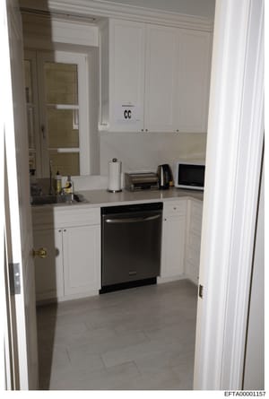 This is a photograph of a modern kitchen interior featuring white cabinetry, stainless steel appliances, and light tile flooring. The image includes an evidence marking 'CC' visible on the upper cabinet, indicating this is a crime scene or investigat