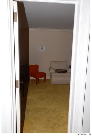 This is an evidence photograph showing the interior of a room with two-tone painted walls (gray upper, beige lower), a tan/cream colored chair with fringe, a red modern chair, and a brown object on the chair. A small evidence marker labeled 'DD' is v