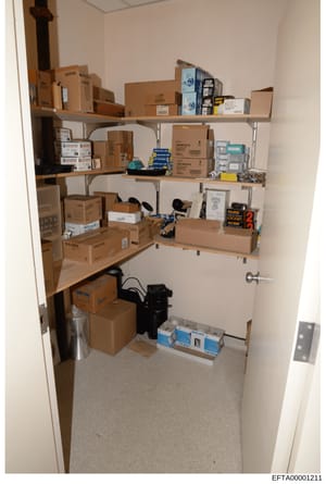 This is an evidence photograph showing the interior of a storage closet containing multiple cardboard boxes and equipment, likely from one of Epstein's properties. The closet contains various packaged items including Philips-branded boxes, electronic