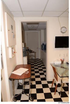 This is a photograph of an interior kitchen and hallway space, showing the layout and furnishings of what appears to be a residential property. The image captures details of appliances, flooring, cabinetry, and general room configuration that may be 