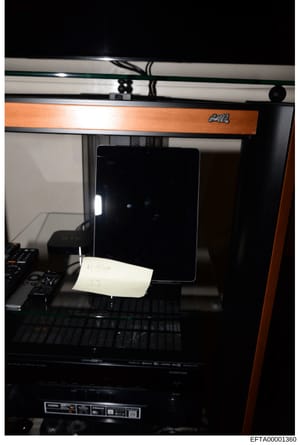 This is a photograph of a 3D printer (appears to be a MakerBot or similar consumer-grade model) with an orange/wooden trim. The image shows the interior of the printer with a black screen/display panel and a white note or paper placed inside the prin