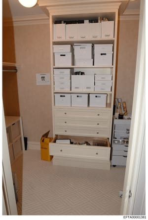 This photograph shows a large built-in closet or storage room containing numerous white archival boxes and filing drawers, along with some organizational materials. The closet appears to be part of a residence and contains what looks like a systemati