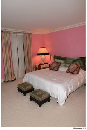 This is a photograph of a residential bedroom interior, showing contemporary decorating style with a prominent pink color scheme. The image documents the interior design and furnishings of what appears to be one of the properties under investigation,