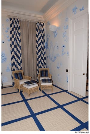 This is a photograph of an elegantly decorated interior room featuring a coordinated blue and white color scheme. The room displays high-end furnishings including two woven chairs with blue striped cushions, patterned curtains with geometric designs,