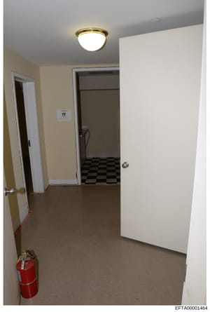 This is a photograph of an interior hallway or corridor space, showing basic architectural features including doorways, flooring, and ceiling fixtures. The image appears to be evidence documentation of a property, possibly related to the investigatio