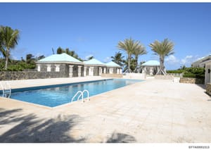 This is a photograph of an upscale tropical residential property featuring a swimming pool, stone pavilions with turquoise roofs, manicured landscaping with palm trees, and stone wall features. The image appears to be from an Epstein-related property