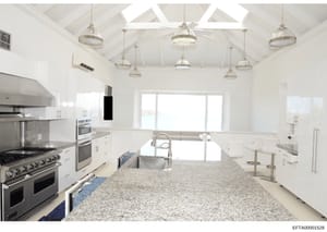 This is a photograph of a contemporary kitchen interior, likely part of property documentation or evidence from the investigation. The image shows a professionally designed kitchen space with luxury finishes, stainless steel appliances, granite count