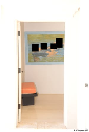 This is a photograph of an interior room, likely part of a residential or commercial property under investigation. The image shows a doorway view into a room with beige/cream colored walls, a framed seascape artwork on the wall with redacted figures,