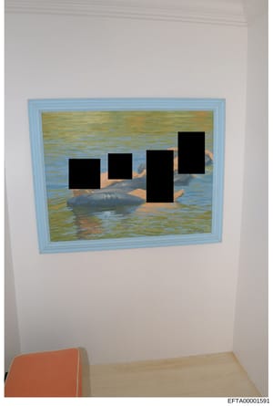 This is a photograph of an interior room showing a framed painting with a light blue frame mounted on a white wall. The painting depicts a water scene with green and blue tones. Four black redaction blocks have been applied over figures or subjects w