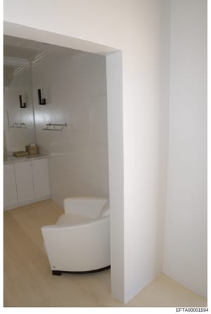 This is a photograph of a modern bathroom interior featuring a contemporary white toilet, vanity with mirror and lighting fixtures, and a shower enclosure. The image appears to be documentation of a property interior, likely taken as part of an evide