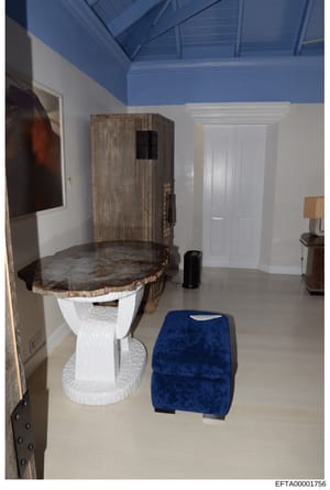 This is an evidence photograph showing the interior of a bathroom or property room, featuring an ornate toilet with a decorative wooden seat and trunk-like upper structure, white porcelain base, and artistic furnishings. The room has a distinctive tw