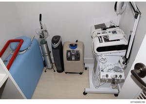 This photograph shows an overhead view of a room containing various medical or cosmetic treatment equipment, including what appears to be oxygen concentrators, a humidifier, and specialized treatment machines. The image documents the contents and lay