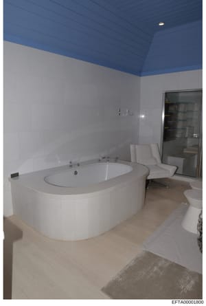 This is a photograph of a luxury bathroom interior featuring a large curved white soaking tub, modern fixtures, and contemporary design elements. The image appears to be taken as evidence documentation of a property interior, likely from one of Epste